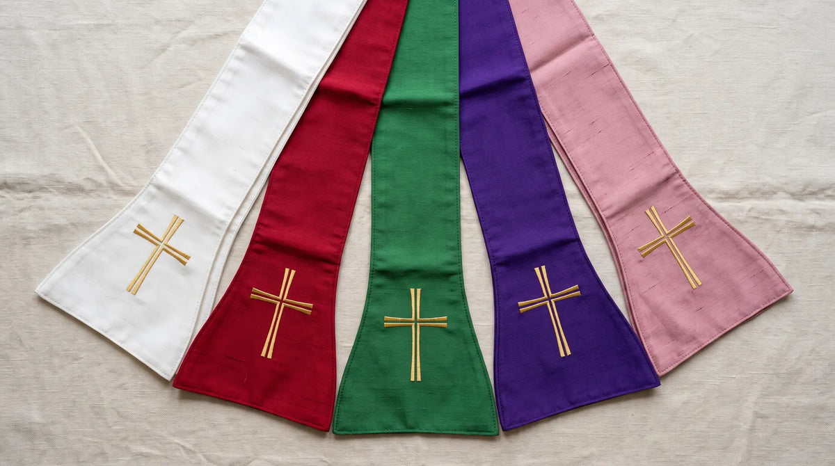 Stoles in white, red, green, violet and rose laid out in a fan on pale linen