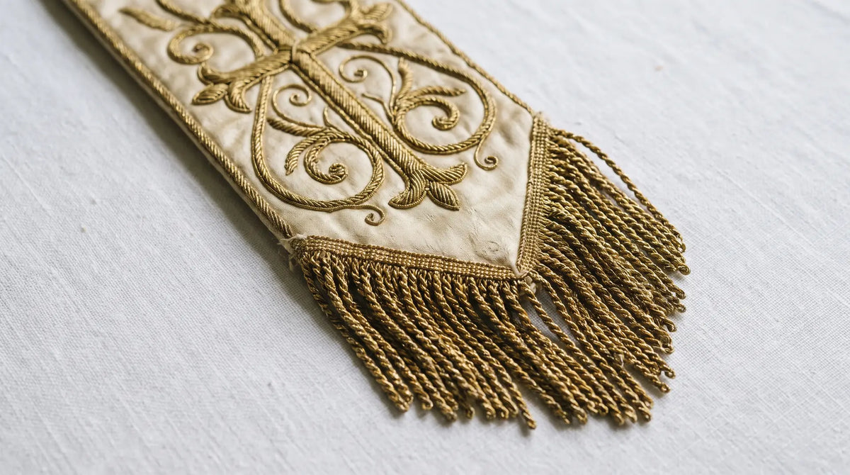 Close detail of the goldwork embroidery and bullion fringe on an ivory and gold ordination stole