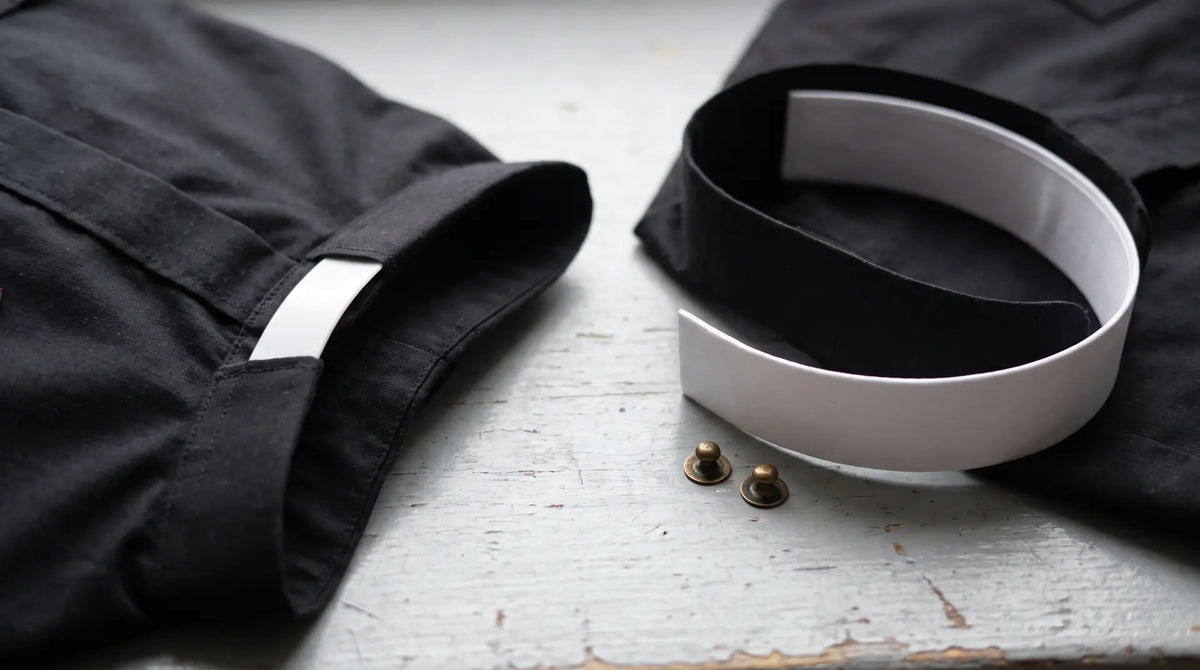 A tab collar shirt beside a neckband shirt with a detachable band collar and brass studs