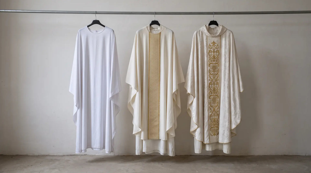 Three white chasubles on a rail showing the difference between plain polyester, mid-weight woven and hand-embroidered silk damask