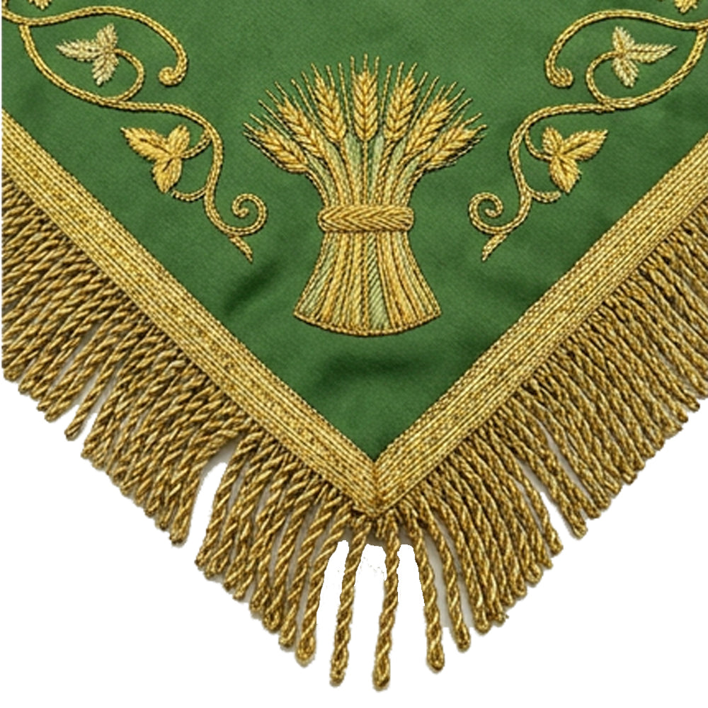 Close-up of the green chalice veil's corner, showing the embroidered wheat sheaf, gold vine scrollwork and bullion fringe.