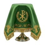 The green chalice veil draped over a chalice, with the Chi Rho to the front and wheat sheaves along the lower border.