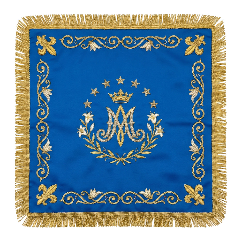 Marian blue chalice veil laid flat, showing the crowned Ave Maria monogram in a wreath of lilies with fleur-de-lis at the corners.