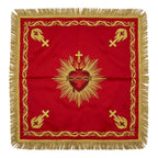 Red Sacred Heart chalice veil laid flat, showing the crimson and gold heart crowned with thorns and set in rays, with gold emblems at the corners.