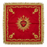 Red Sacred Heart chalice veil laid flat, showing the crimson and gold heart crowned with thorns and set in rays, with gold emblems at the corners.