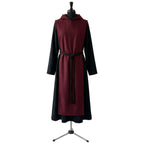 Front view of a black monk habit with a burgundy scapular, hood and black rope cincture.