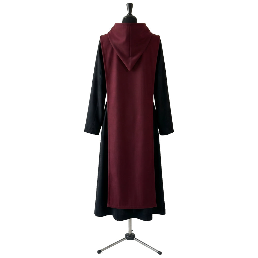 Back view of a black hooded habit showing the burgundy scapular's full length and plain surface.