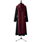 Back view of a black hooded habit showing the burgundy scapular's full length and plain surface.