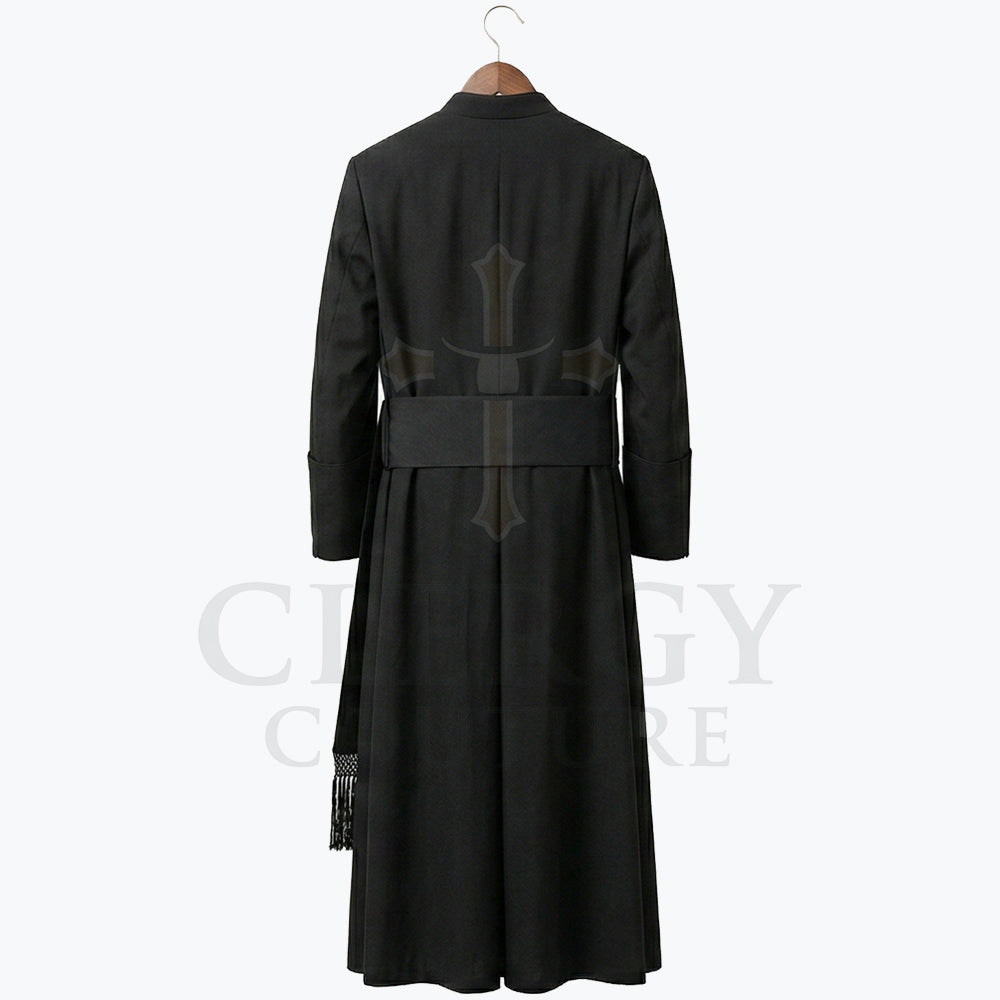 Back view of the black cassock robe, showing the sash carried straight across the waist and the plain full-length skirt.