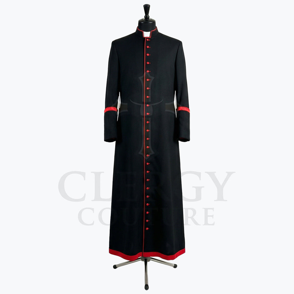 Front view of a black clergy cassock robe with a full-length red button placket and red piping at the collar.
