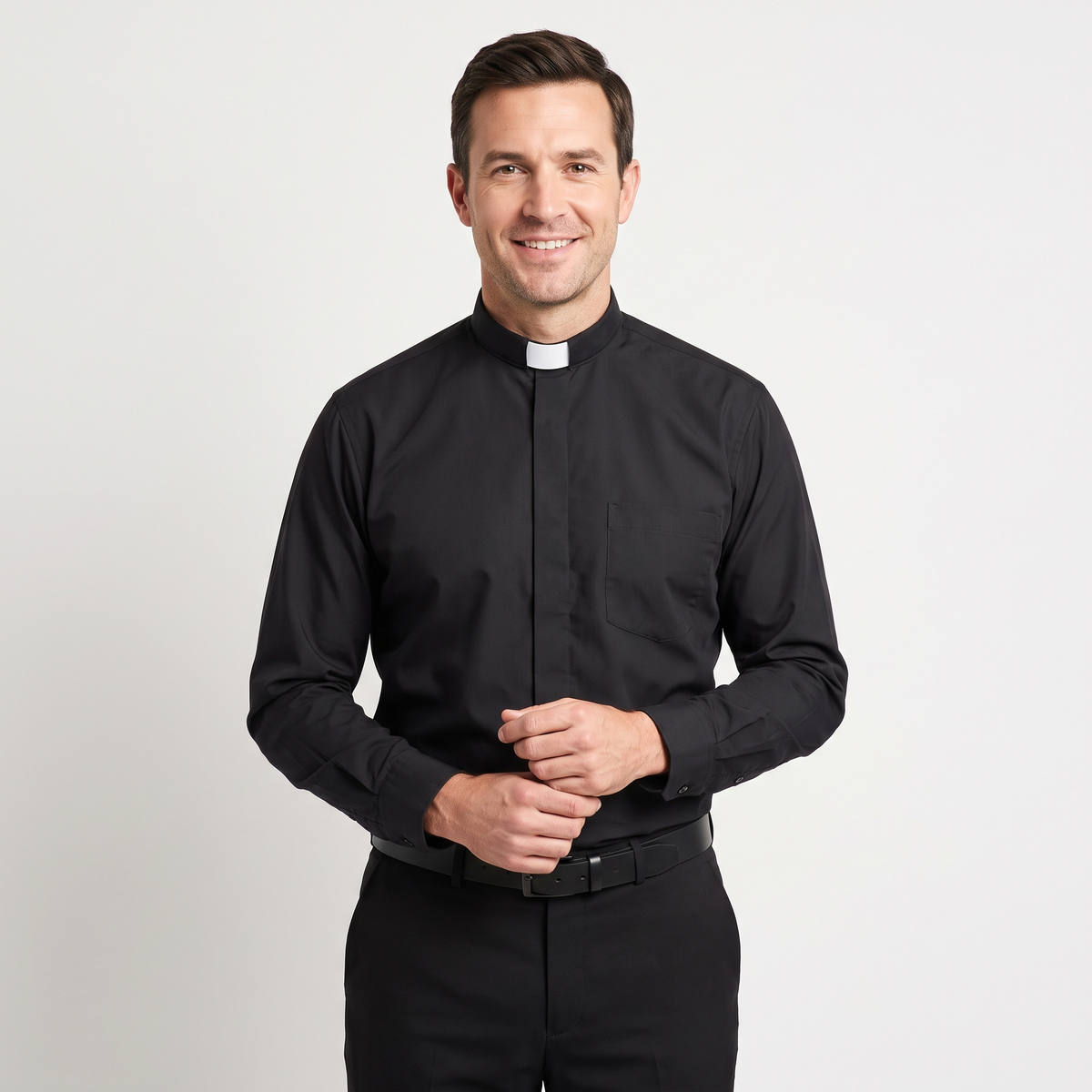 Man wearing the black long-sleeve tab-collar clergy shirt with a white tab (shown for styling, not included), covered placket and left chest pocket, against a light grey background.