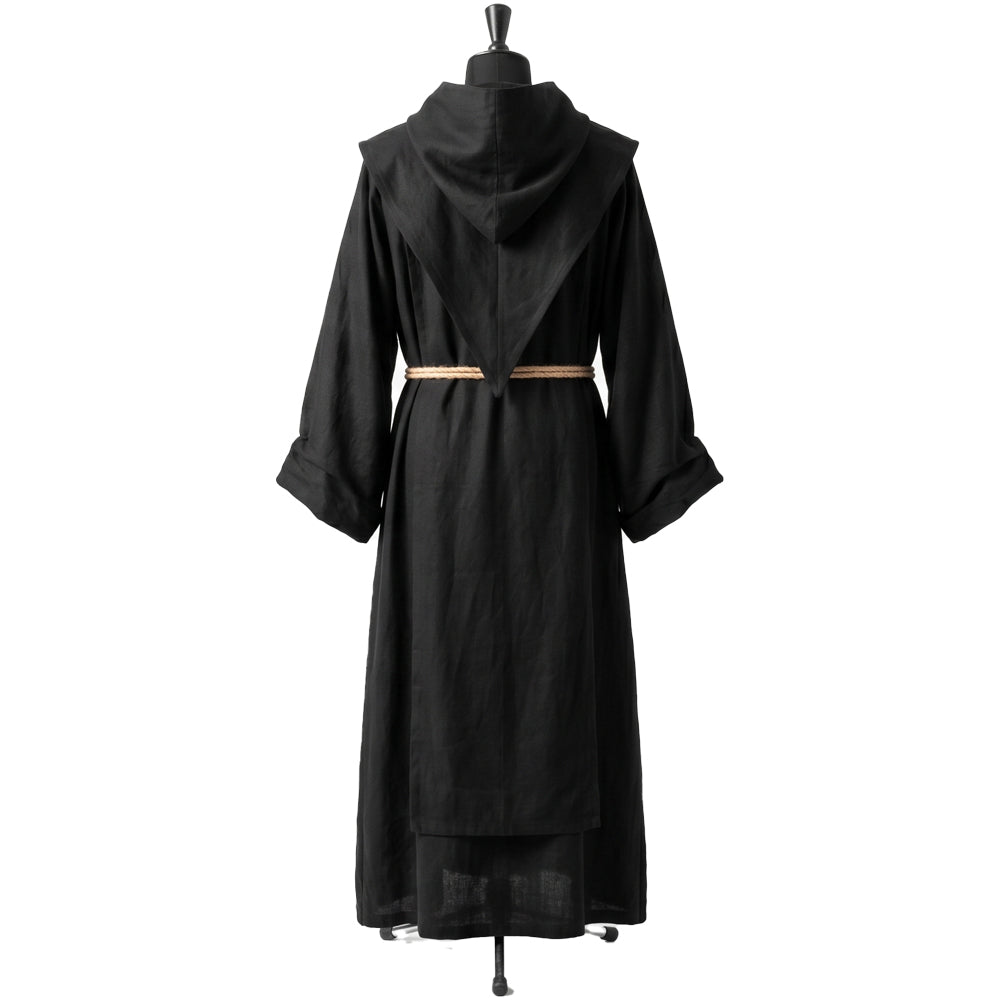 Back view of a black monk habit showing the plain pointed hood and coarse woven cotton texture.