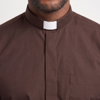 Close-up of the tall brown tab collar with a white tab, the covered button placket and the top of the chest pocket.