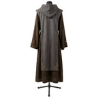 Back view of a brown hooded habit showing the grey scapular's gold cross embroidery near the hem.