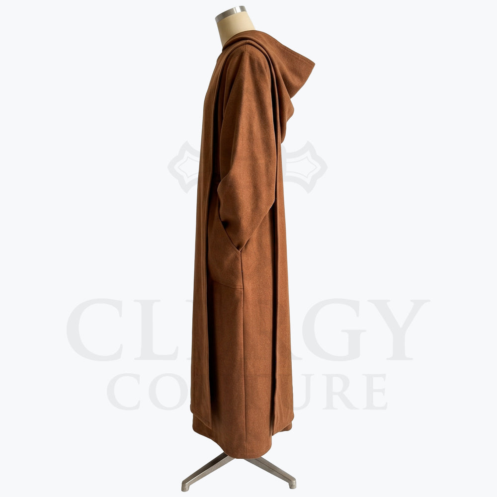 Side profile of a brown monk habit showing the patch pocket, dropped sleeve and ankle-length hem.