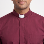 Close-up of the tall burgundy tab collar with a white tab, the covered button placket and the top of the chest pocket.