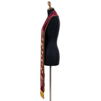 Close side view of the burgundy velvet-look stole's gold grape clusters, vine leaves and wheat sheaf embroidery