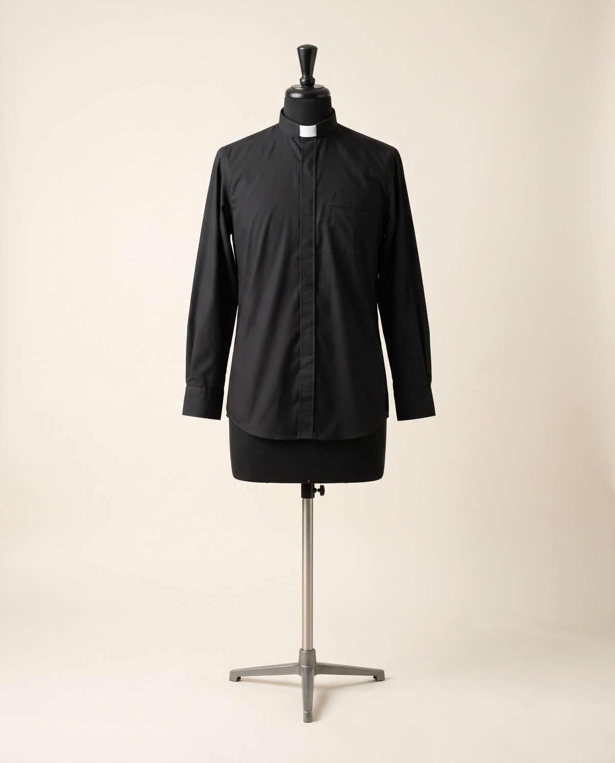 A long-sleeved black clergy shirt with a neckband collar and white tab insert, shown on a tailor's dress form