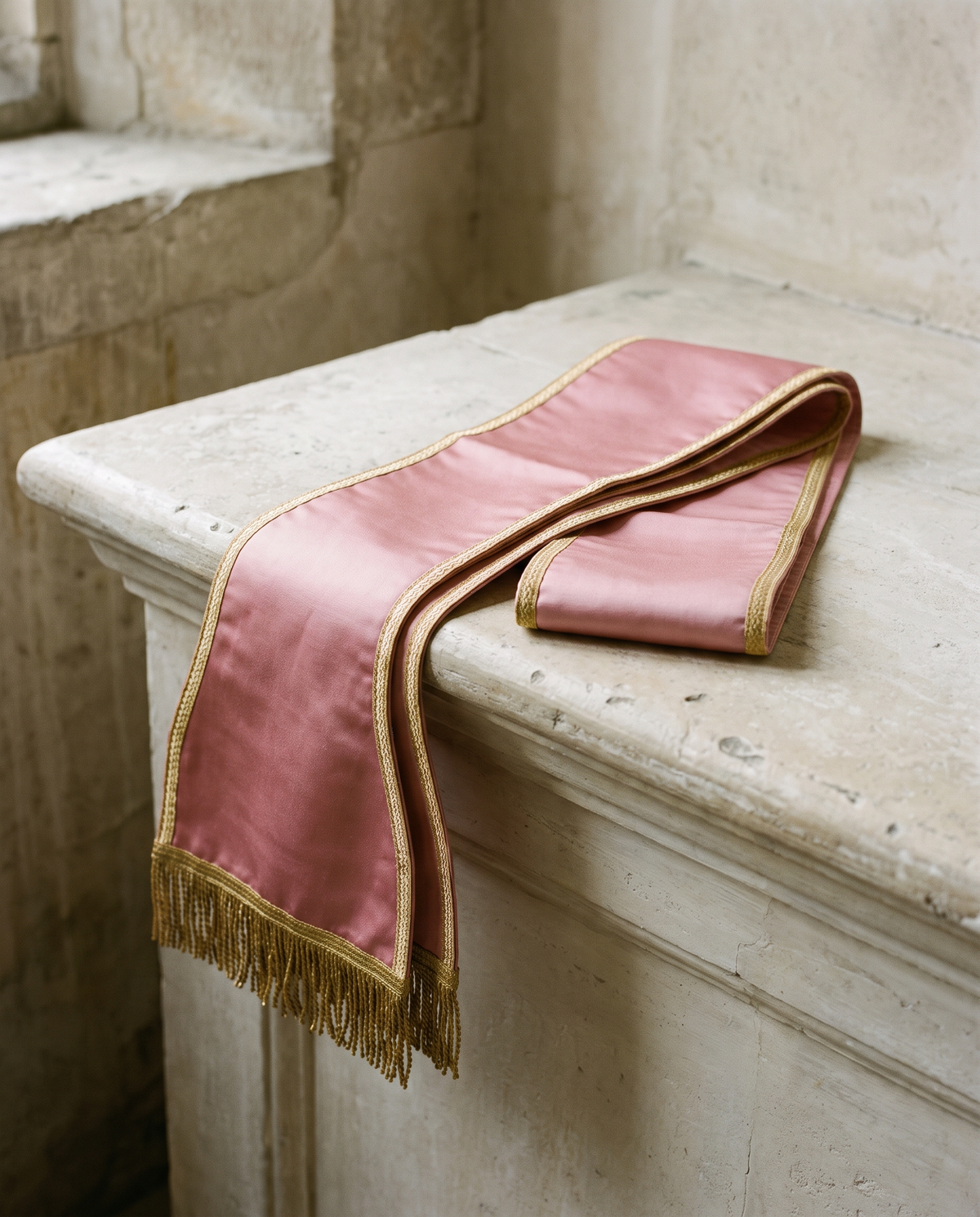 A folded rose stole with gold galloon edging