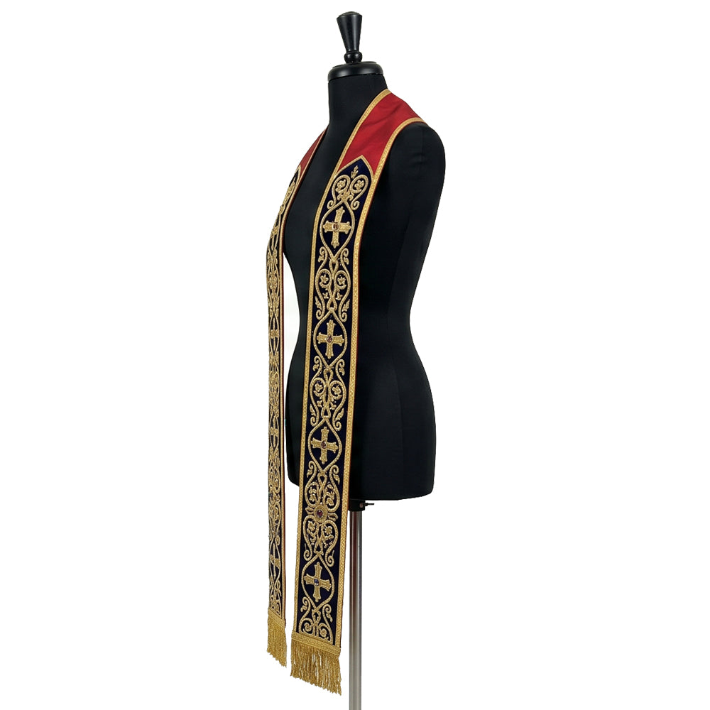 Angled view of the Roman-style stole's navy band, gold scrollwork and gemmed crosses tapering to the fringe.