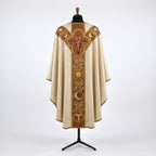Back of the Franciscan chasuble with a Y-shaped terracotta orphrey: the San Damiano crucifix in a gold quatrefoil, doves, olive branches, sun, crescent moon and Tau
