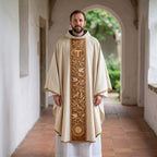 A priest wearing the ivory Franciscan chasuble with terracotta Tau and dove orphrey in a whitewashed cloister