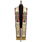 Ivory and gold brocade stole laid flat with a sunburst cross medallion and floral scrollwork, edged in burgundy velvet.