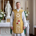 A priest in a lace alb wearing the gold fiddleback chasuble with roses and lilies beside a Marian altar with white lilies