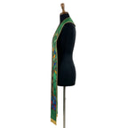 Close view of one green stole panel, showing the brown trunk, green leaf panes and gold-outlined stained-glass tree design.
