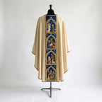 Back of the ivory Holy Family chasuble with a blue orphrey of four gothic-arched scenes: the Annunciation, the Nativity, a shepherd with a lamb and the three kings
