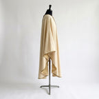 Side view of the ivory Holy Family chasuble showing the full gothic drape and gold-bound hem