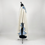Side view of the ivory and blue Marian chasuble showing the gothic drape and pale blue lining
