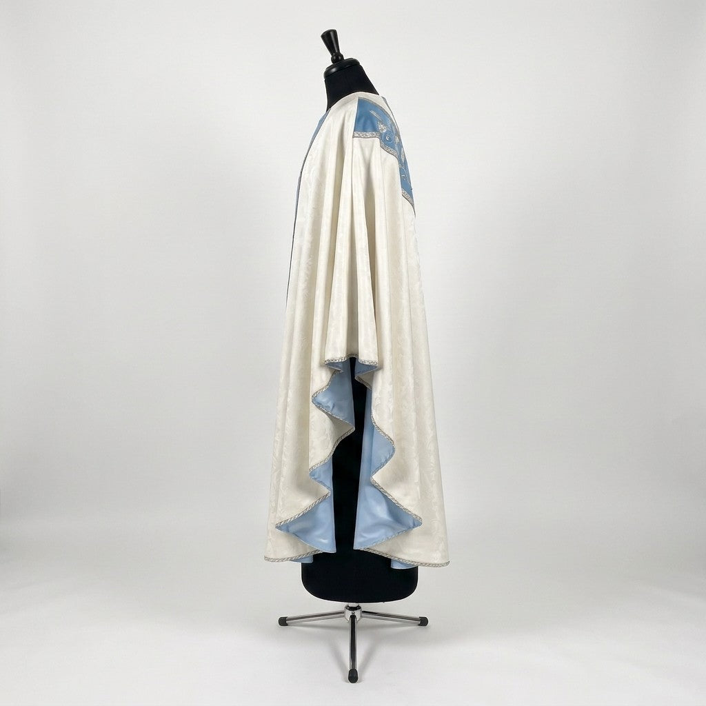 Side view of the ivory and blue Marian chasuble showing the gothic drape and pale blue lining