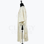 Side view of the ivory dalmatic showing the open sleeve and the gold cross at the end of the stole