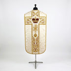 Back of the ivory fiddleback chasuble with a gold cross orphrey: crimson velvet royal crown at the crossing, radiant Chi Rho, orb and cross, and acanthus scroll