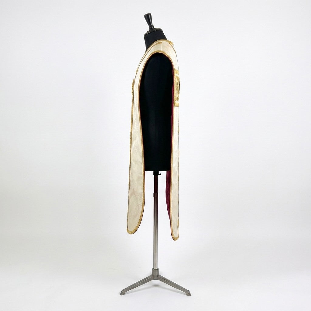 Side view of the ivory fiddleback chasuble showing the open Roman cut and the crimson lining
