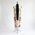 Ivory clergy stole on a bust form, each panel showing a sepia nativity scene from an angel to a shepherd at a campfire.