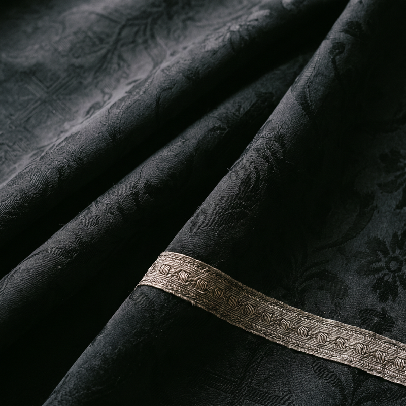 Close detail of black liturgical silk damask with silver galloon trim, worn at Requiem Masses