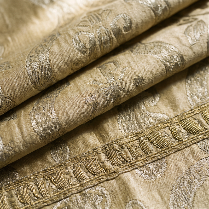 Close detail of antique gold silk brocade with worn goldwork orphrey embroidery
