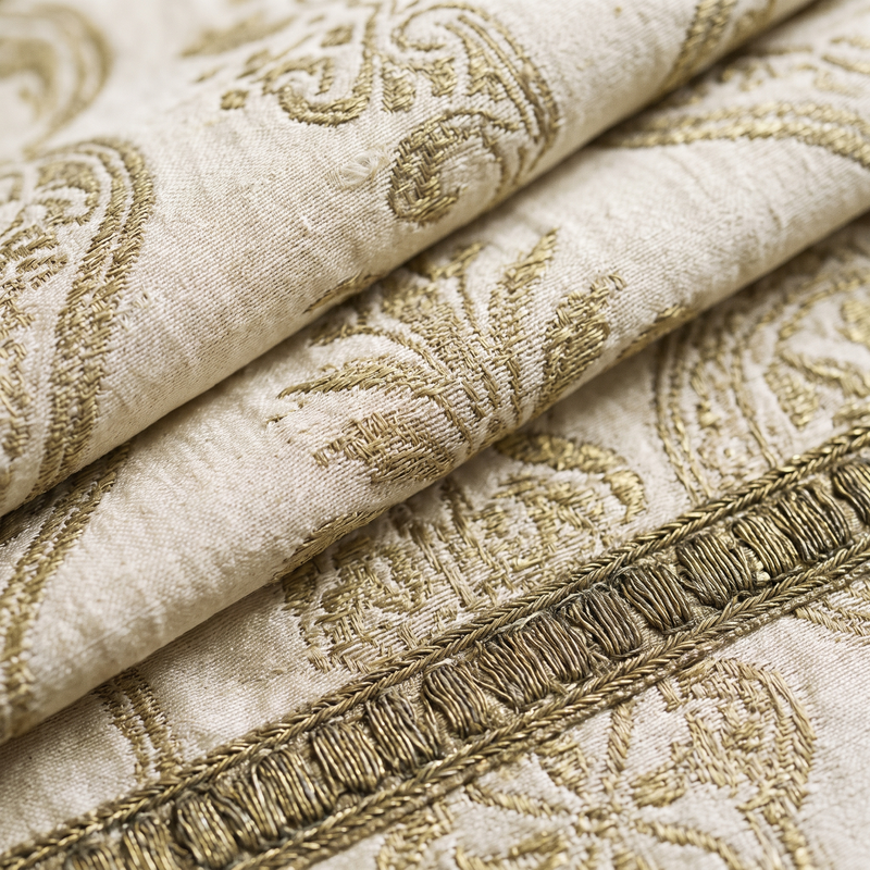 Close detail of ivory and gold silk brocade with aged goldwork orphrey, the festal colour of Christmas and Easter