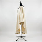 Side view of the ivory satin Nativity chasuble showing the gothic drape and gold-bound hem