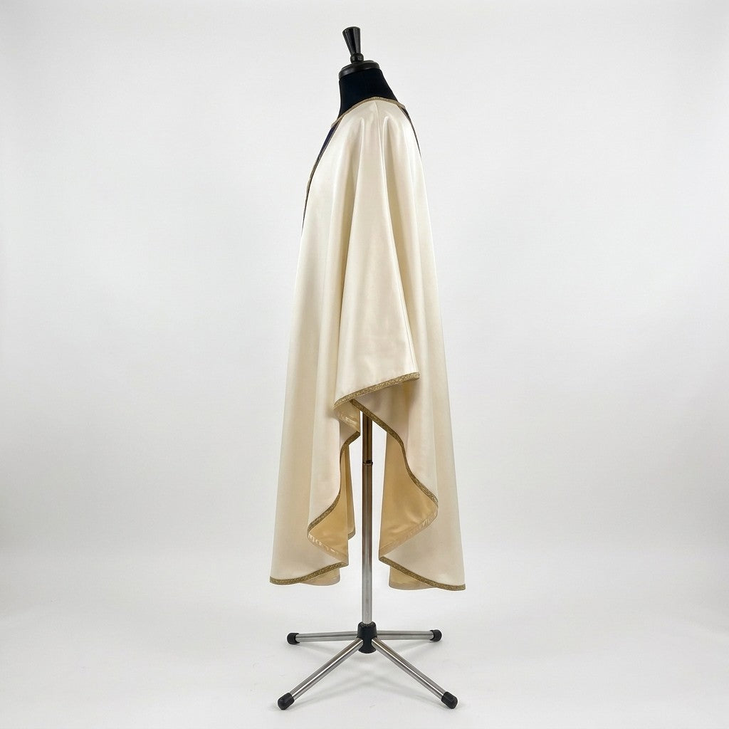 Side view of the ivory satin Nativity chasuble showing the gothic drape and gold-bound hem