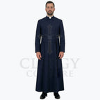 A pastor wearing the navy blue clergy cassock robe, front view, showing the stand collar and the sash belt with tassel.