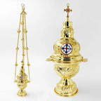 Gold Orthodox censer shown twice, hanging on its three bell chains and again close up, with a cross finial and an enamelled medallion on the lid