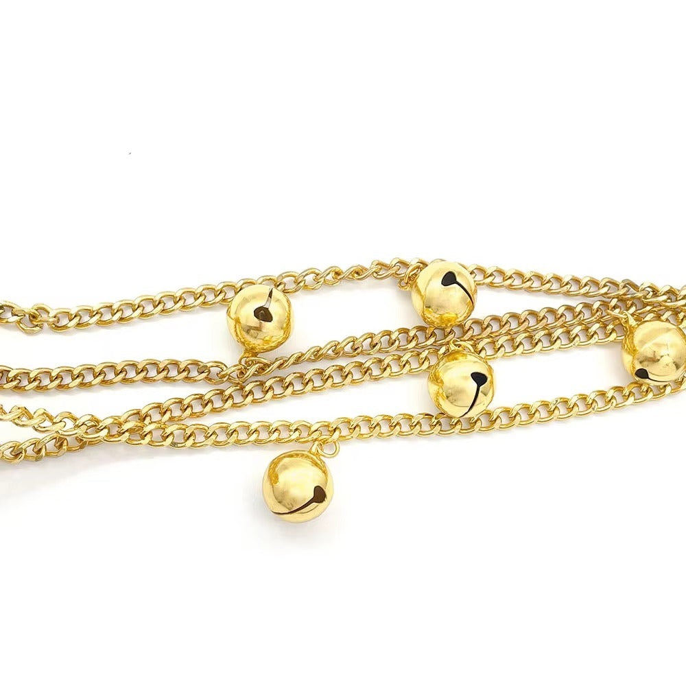 Close up of the gold chains with round bells fixed along them at intervals