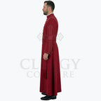 Side view of the deep red cassock robe worn by a model, showing the sash tie and the fall of the skirt.