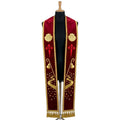 Red velvet-look stole laid flat with a shell, a red Cross of Saint James, a pilgrim's staff and a starry winding path.