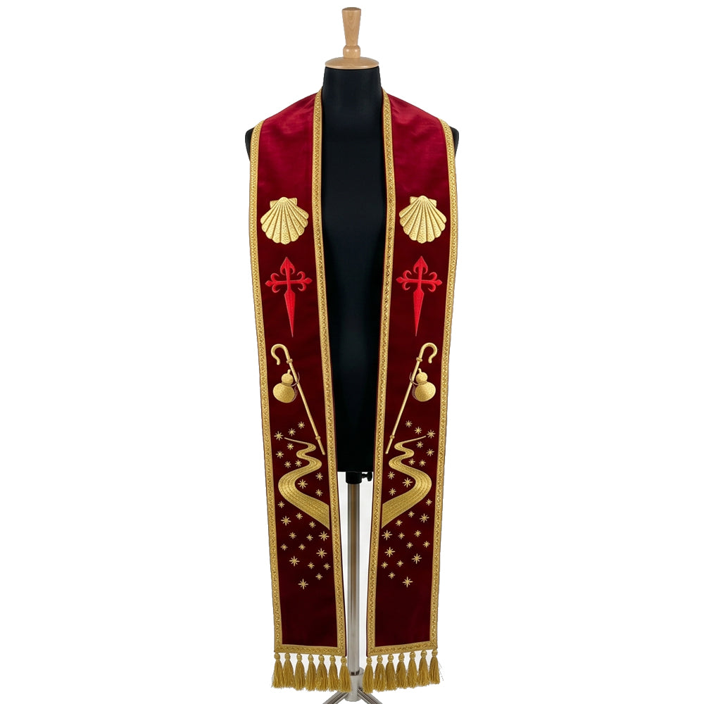 Red velvet-look stole laid flat with a shell, a red Cross of Saint James, a pilgrim's staff and a starry winding path.