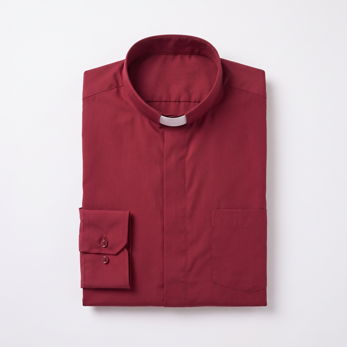 The red long-sleeve clergy shirt folded, with the collar standing and a buttoned barrel cuff visible.