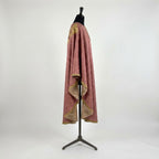 Side view of the rose damask chasuble showing the gothic drape, gold trim and champagne lining